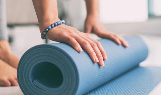 woman rolling up a yoga mat