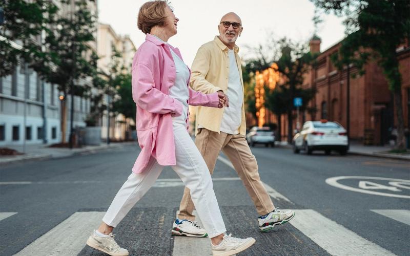 a man and woman walking across a street